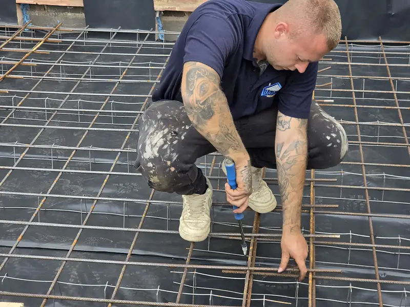 Barlow team member fixing steel reinforcement mesh before a pour