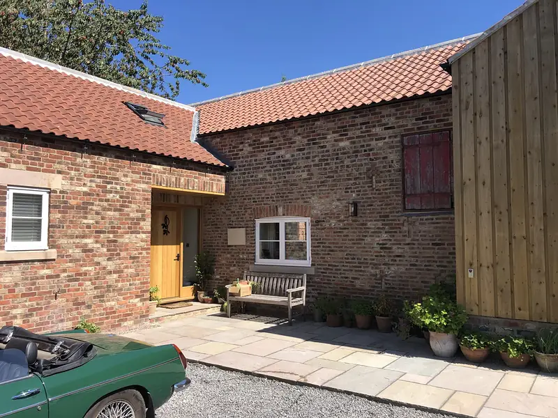 Block paved drive in front of a brick and pantile house
