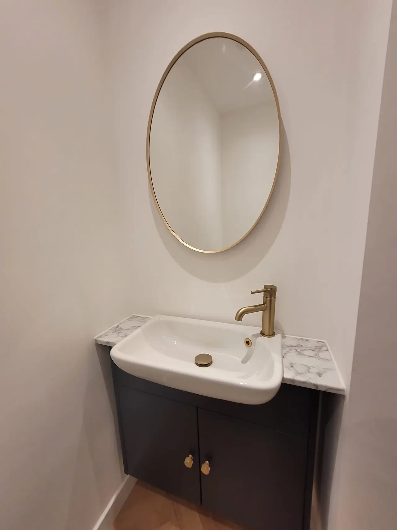 Brass taps and oval mirror in the shower room