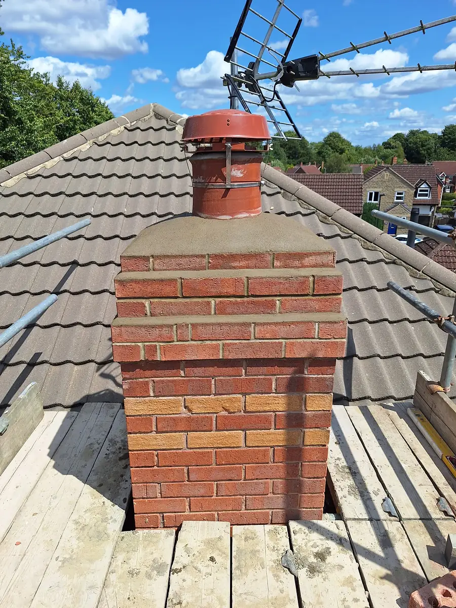 Brick chimney rebuilt on the roof