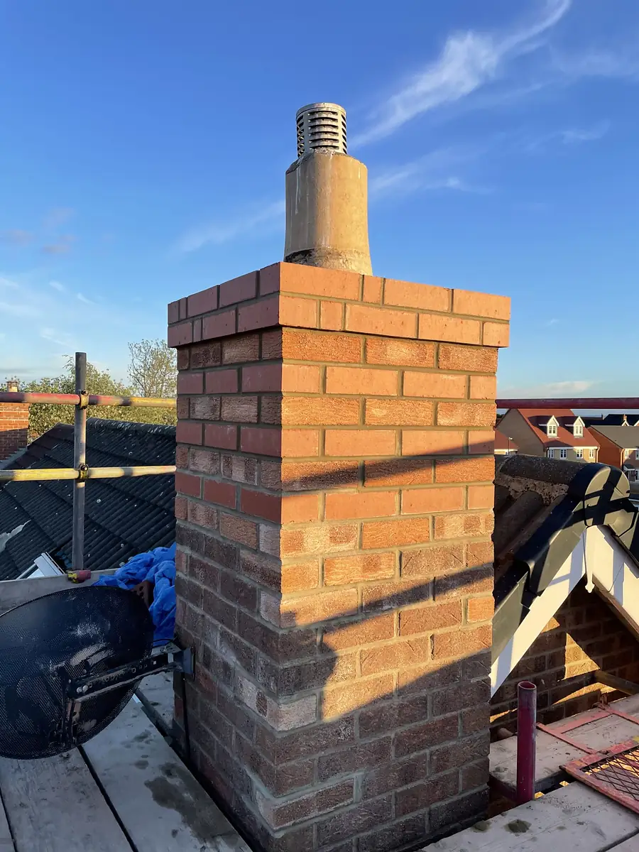 Brick chimney stack rebuilt above the roof line