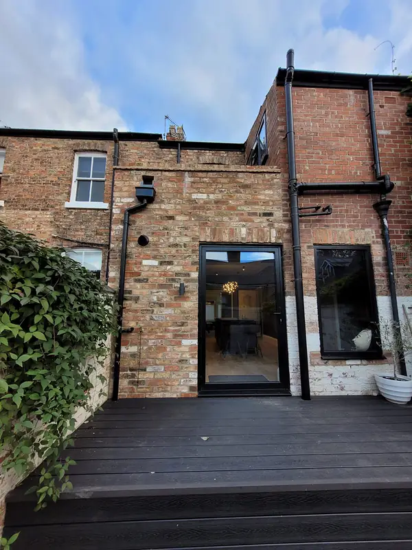 Brick rear extension with glazed doors onto a deck