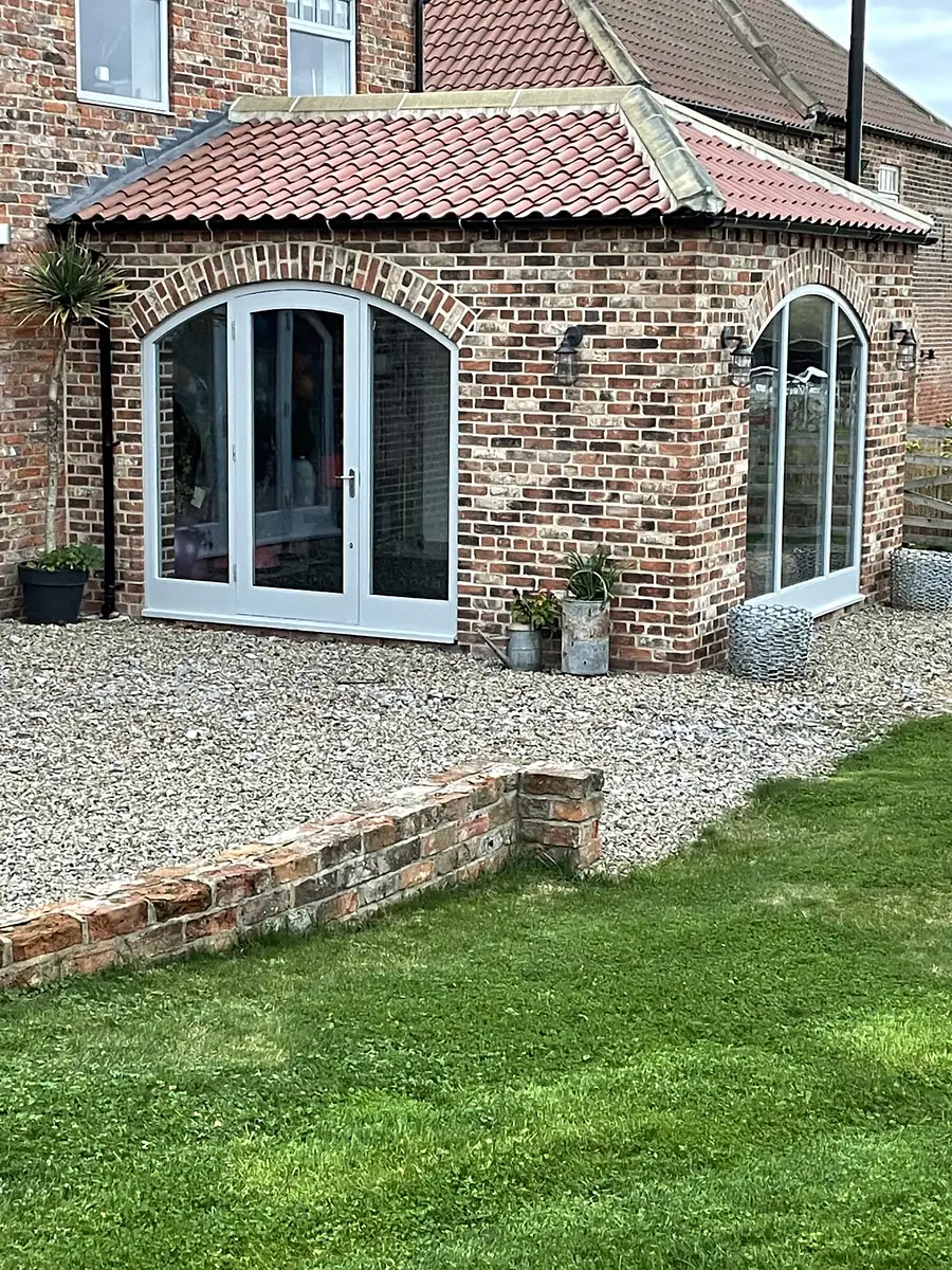 Brick barn with arched glazed doors onto the garden