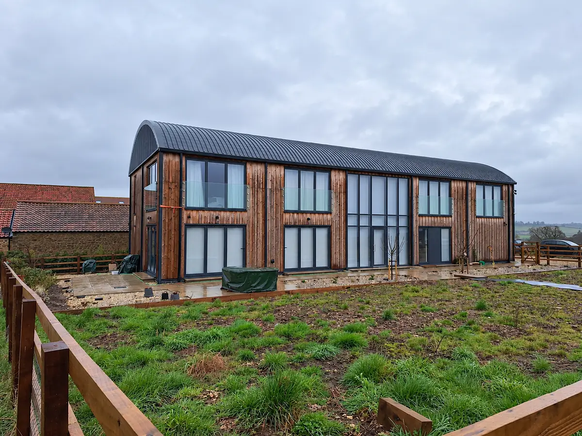 Curved metal roof on a timber clad house