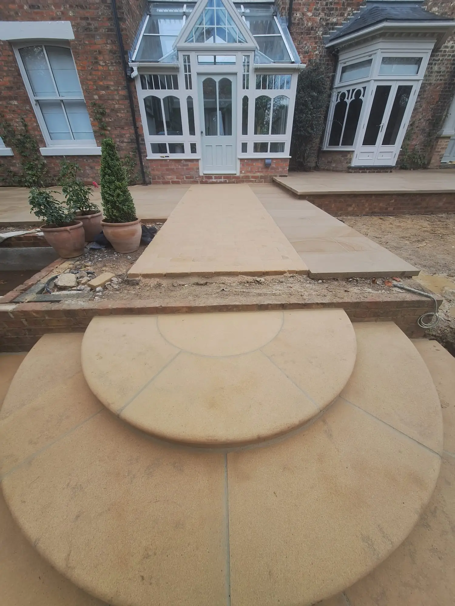 Curved sandstone steps to a conservatory