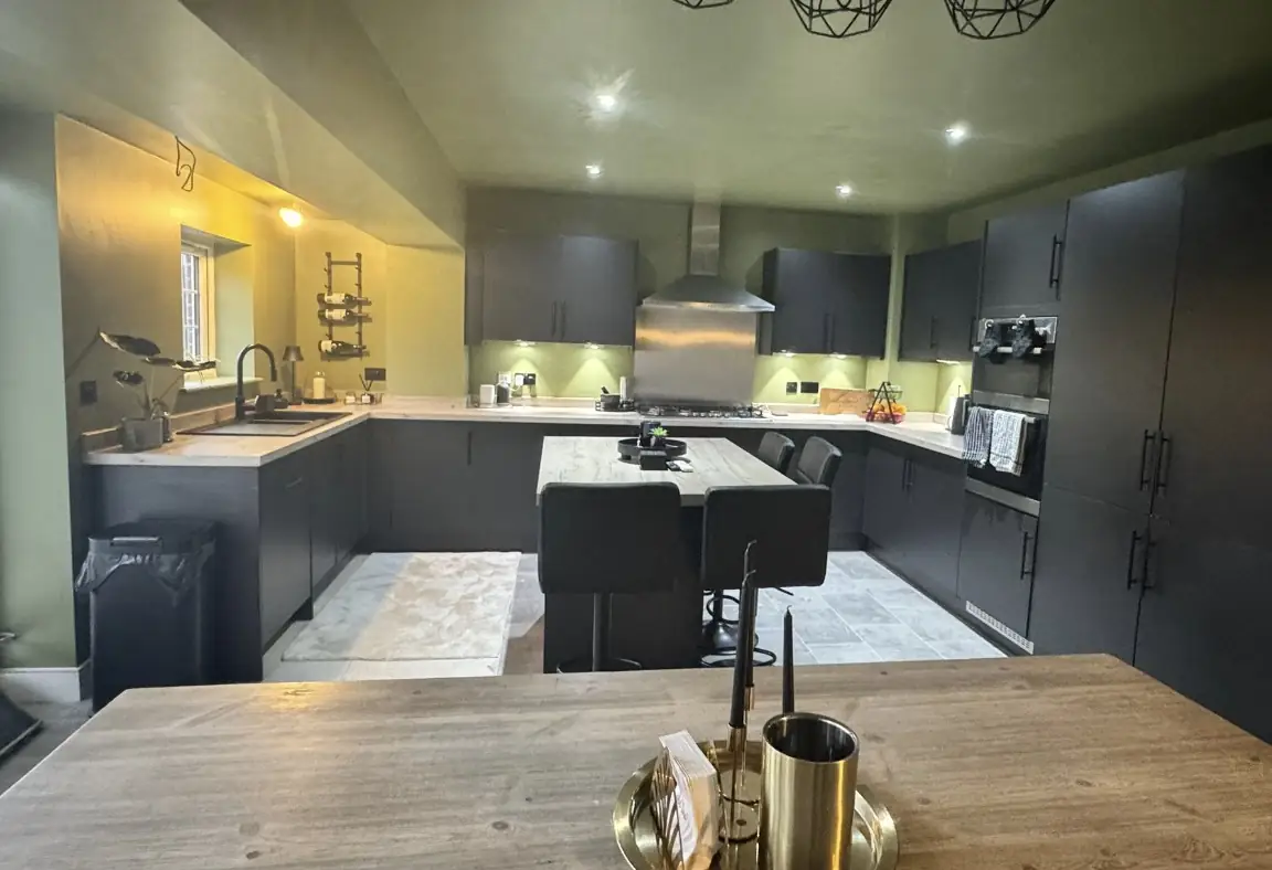 Dark kitchen with an island and pendant lights