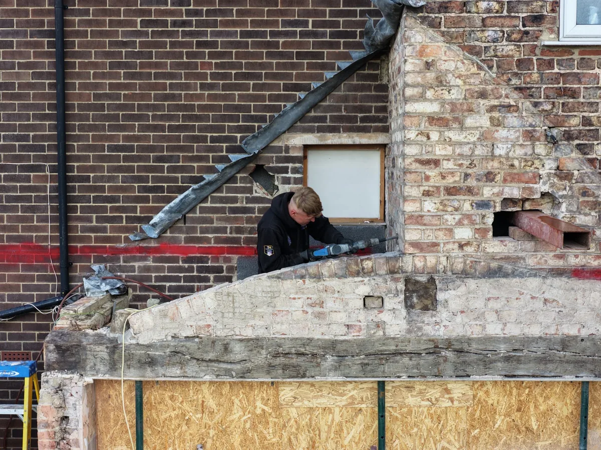 Drone close up of our team cutting out old brickwork at height