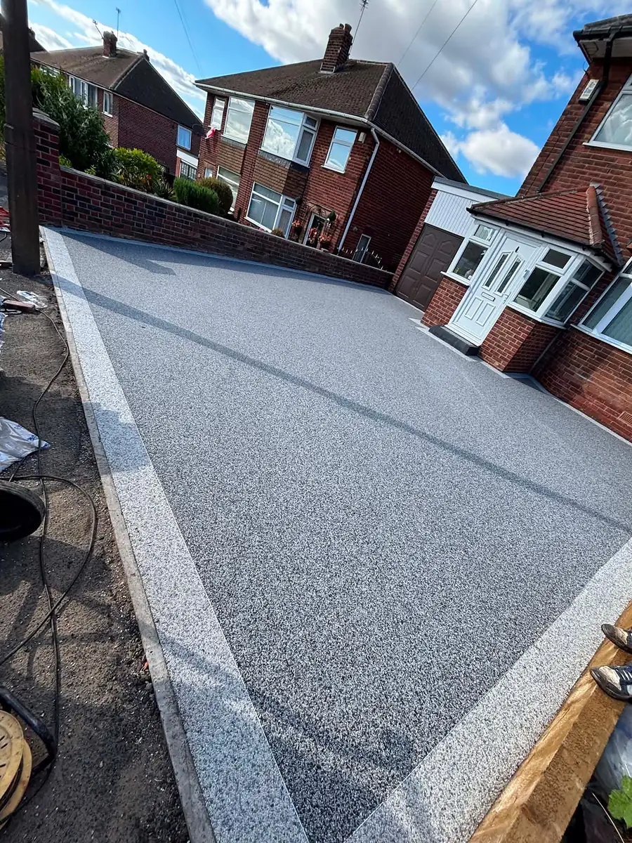Grey resin driveway with a light border