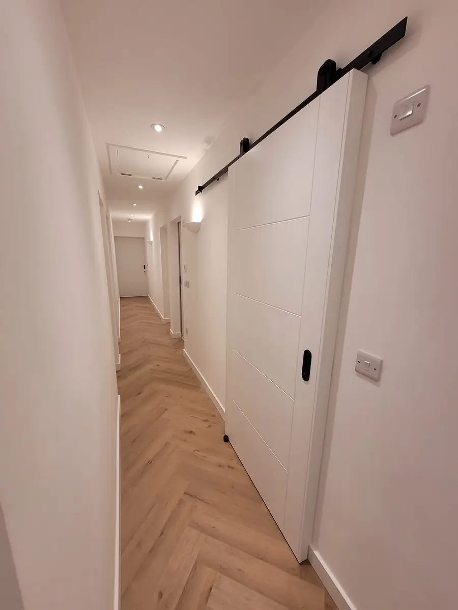 Hallway with herringbone floor and sliding doors