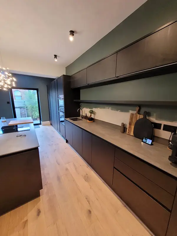 Long kitchen with an island and an oak floor