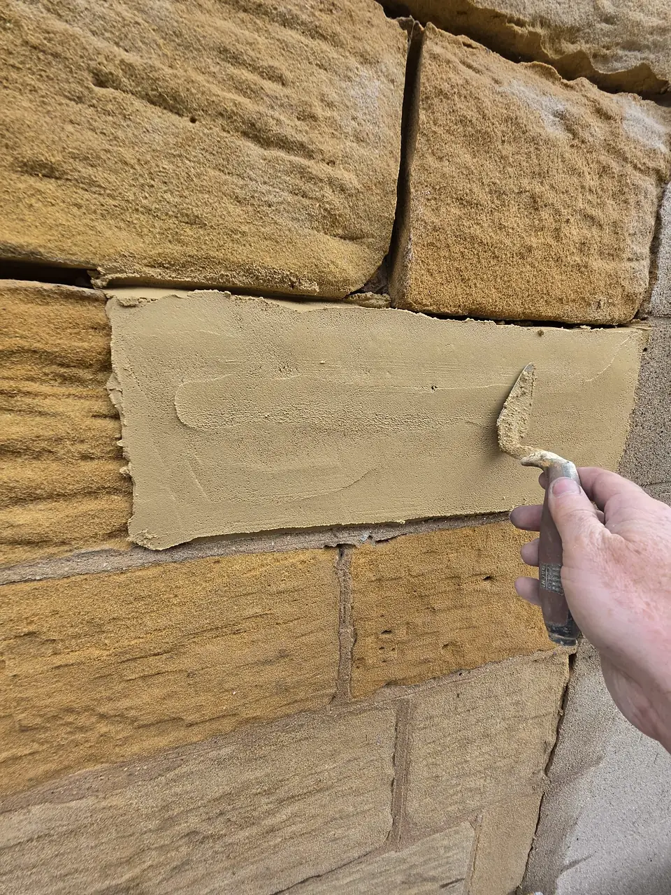 New stone face being set into an old wall