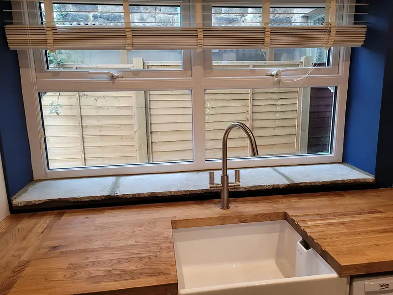 Oak worktop and deep window seat in a renovated kitchen