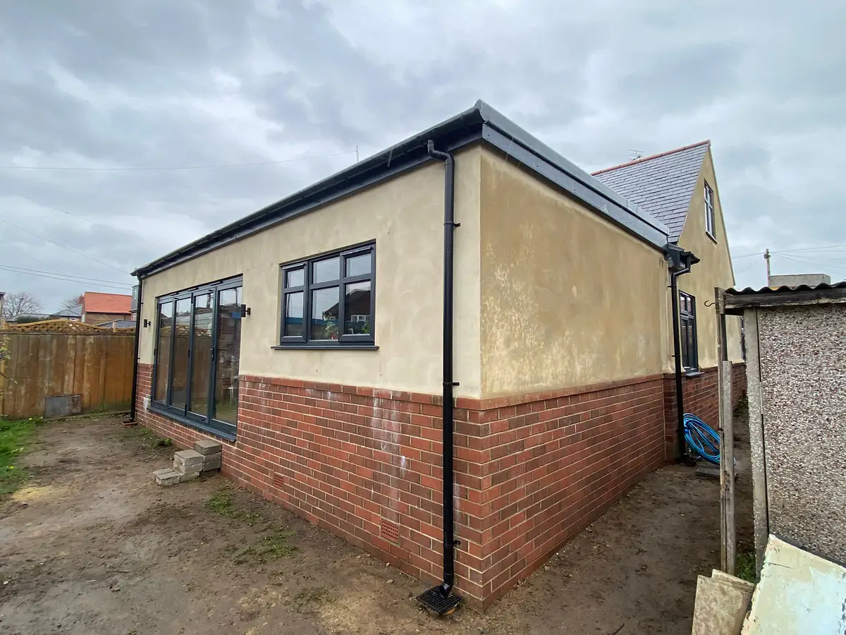 Rendered extension on a brick plinth