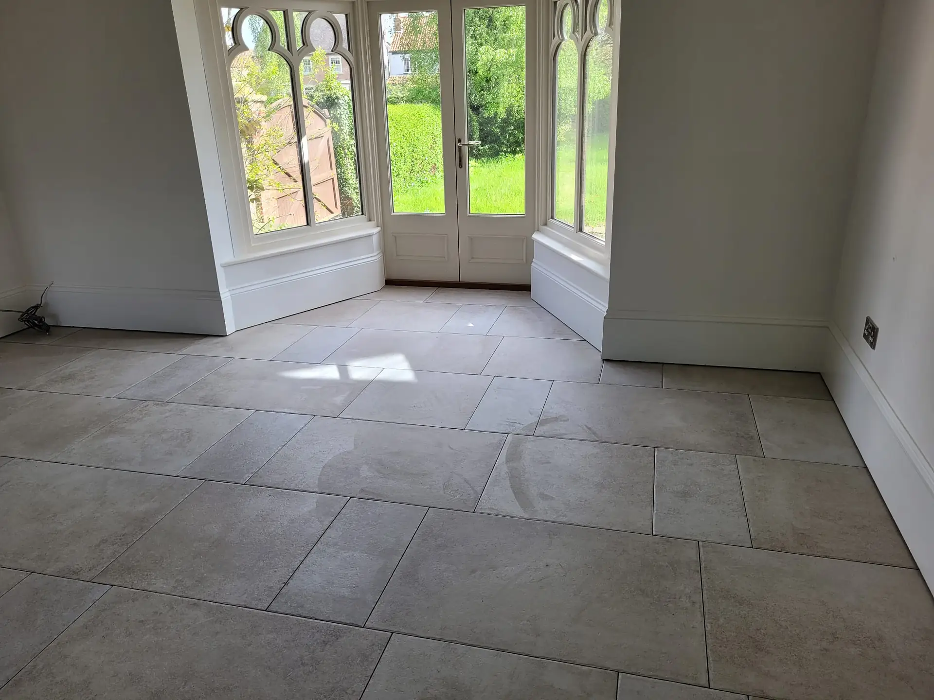 Renovated room with arched windows and a stone floor