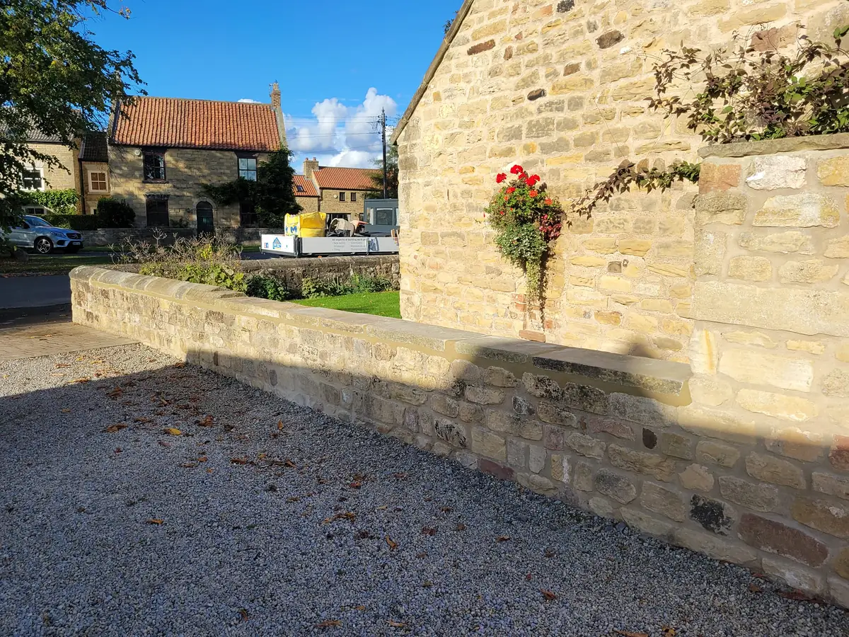 Stone boundary wall rebuilt in the original stone