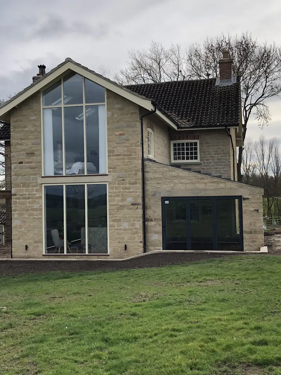 Stone extension with full height glazed gable