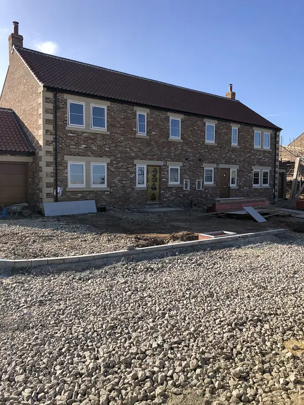 Stone farmhouse new build with a gravel drive