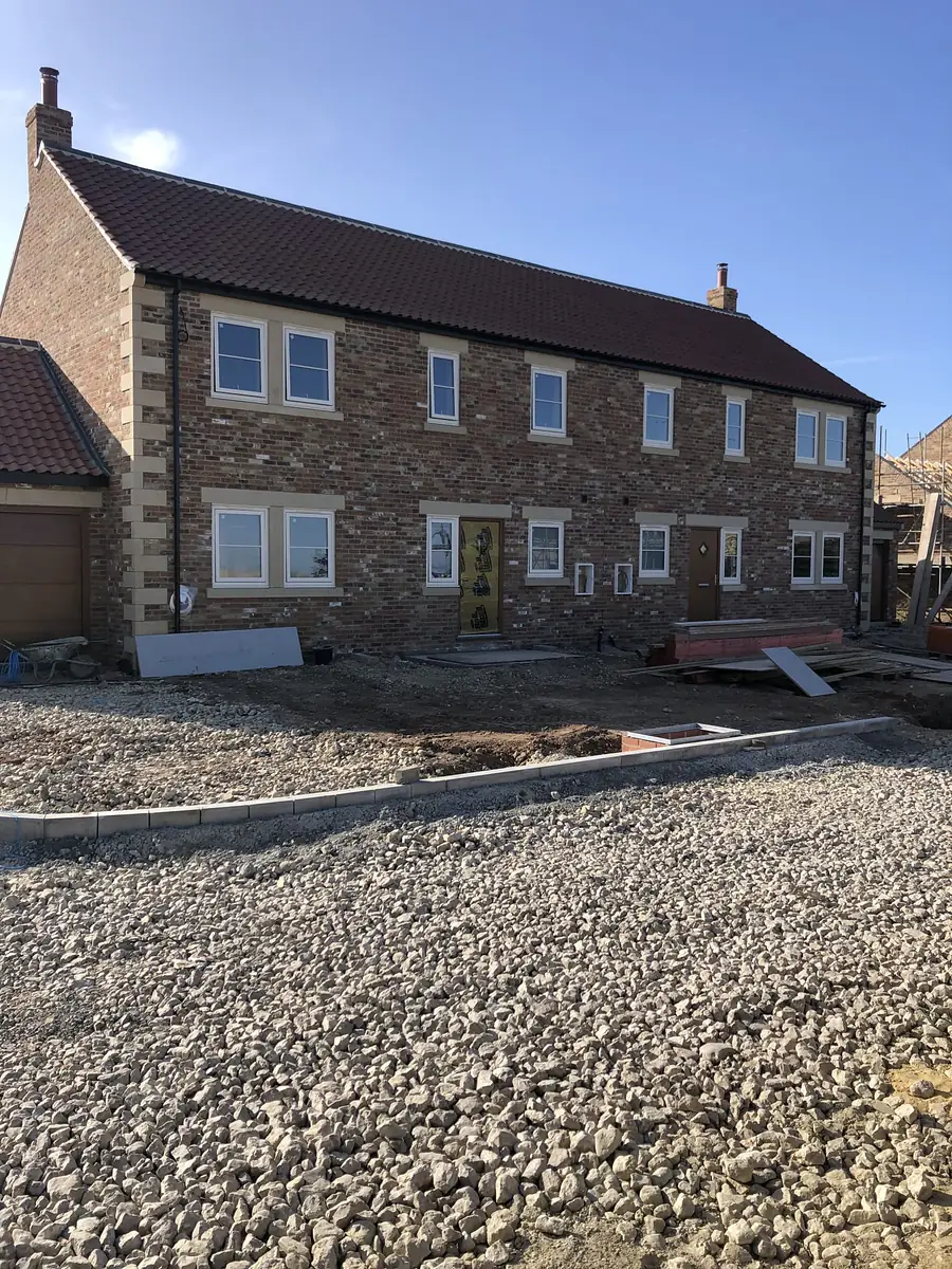 Stone farmhouse new build with a gravel drive