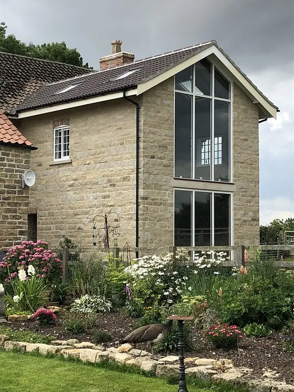 Stone house with a full height glazed gable