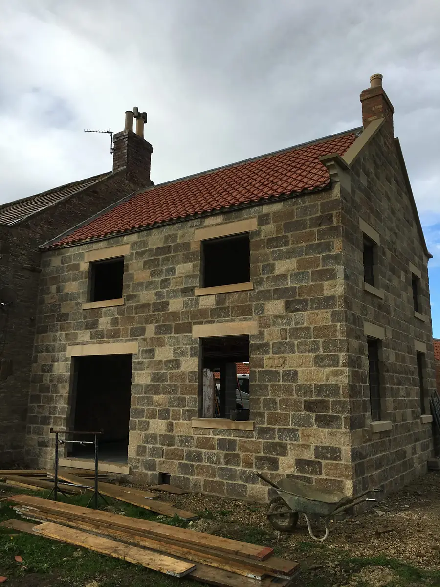 Stone shell of a new house under scaffold