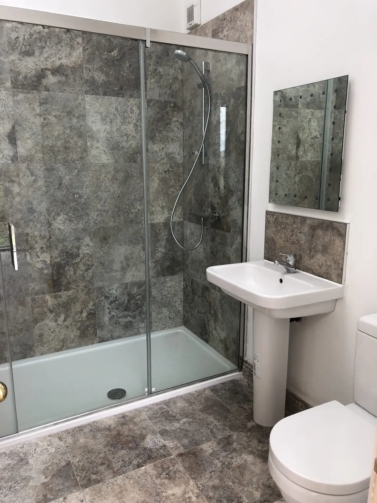 Stone tiled shower with glass screen