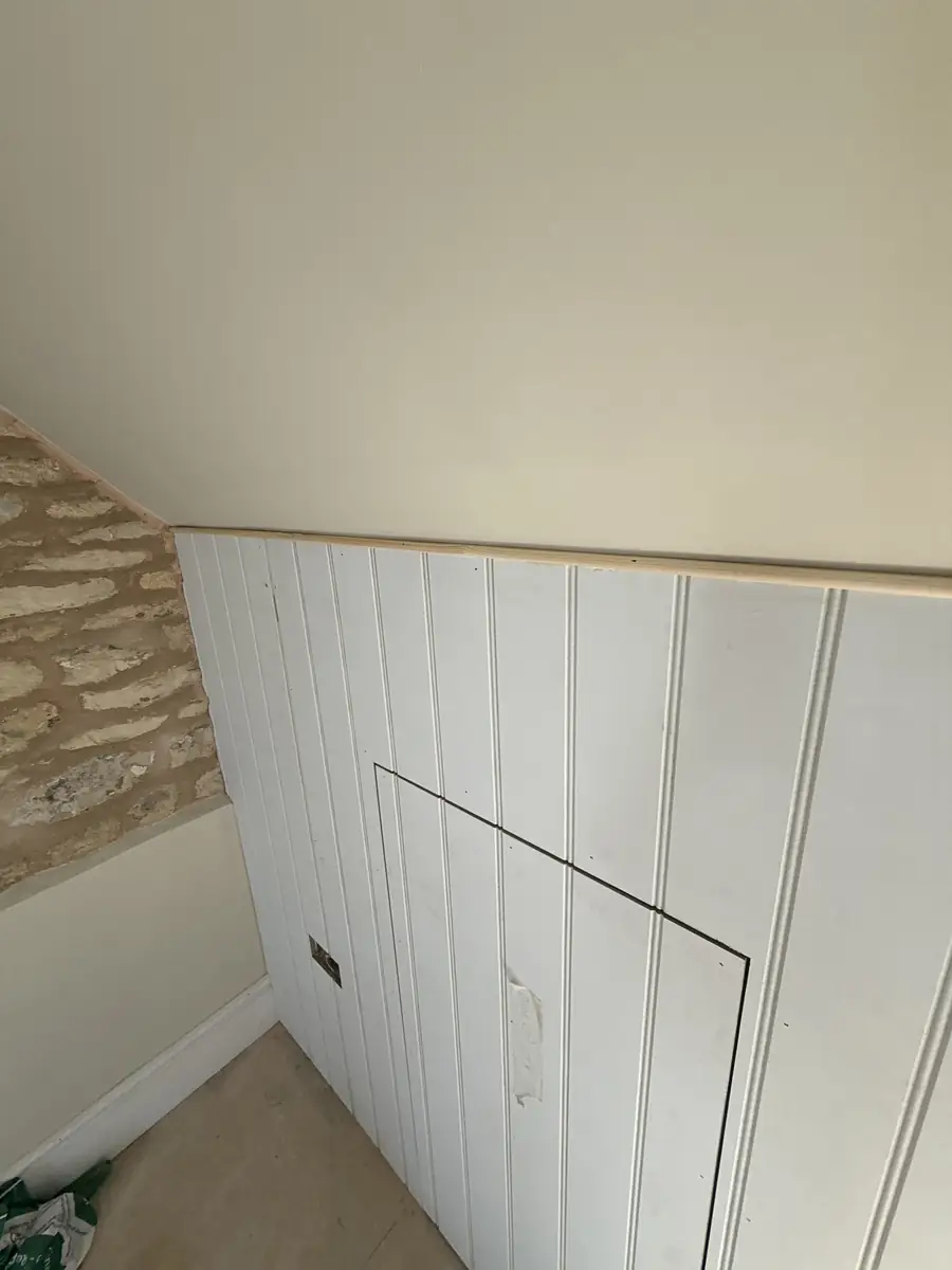 Tongue and groove panelling with a hidden door in a loft room
