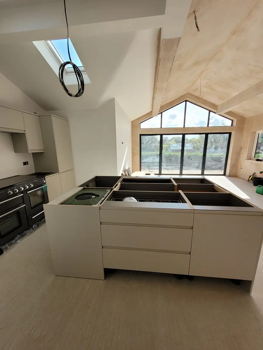 White kitchen under a glazed gable with rooflights