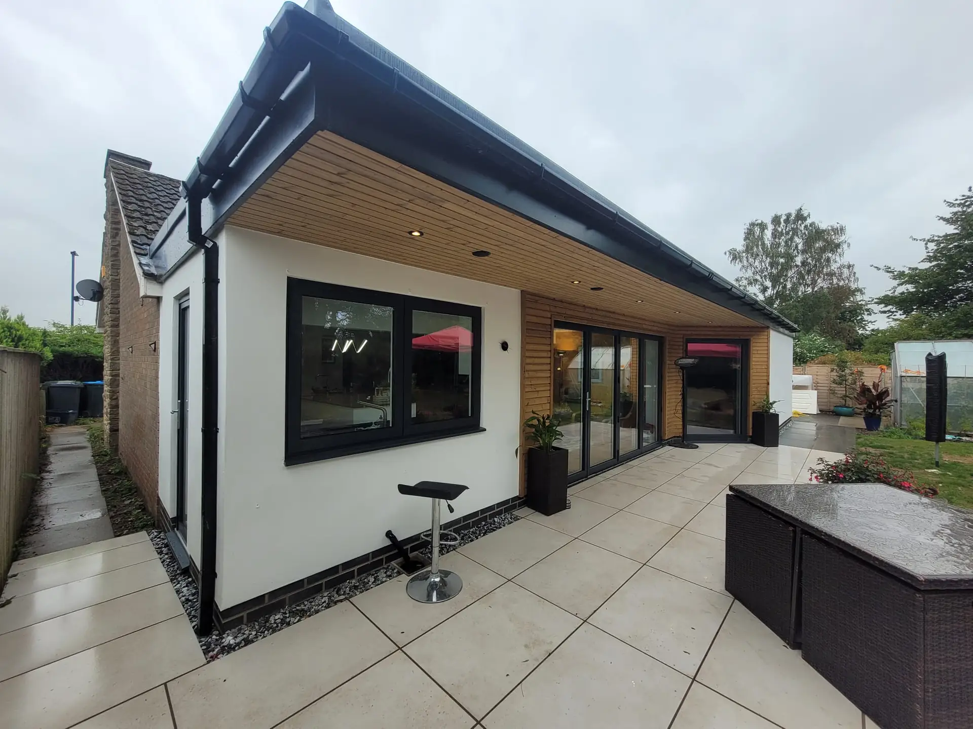 White rendered extension with a porcelain patio